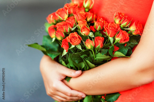Fototapeta Naklejka Na Ścianę i Meble -  Beautiful bright orange roses in child's hands