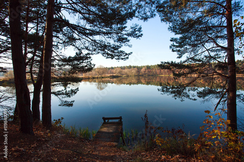 Fototapeta Naklejka Na Ścianę i Meble -  Old small wooden pier for fishing in autumn forest lake