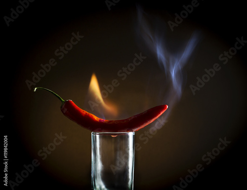Red hot pepper with flames on the glass