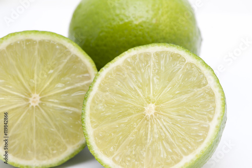 Close-up of two fresh nutritious limes, on white