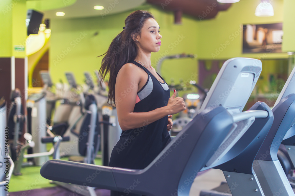 Fit woman exercising on treadmill in gym. Fit woman exercising on treadmill in gym.