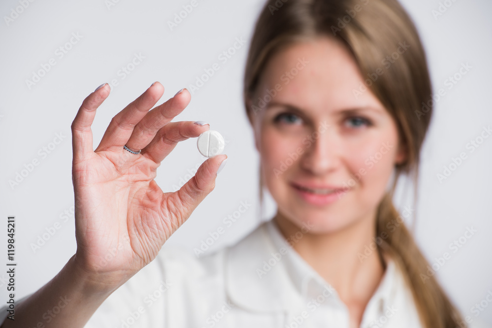 Serious medical woman with pill. Young beautiful nurse holding medicament on white. Serious medical woman with pill. Young beautiful nurse holding medicament on white.