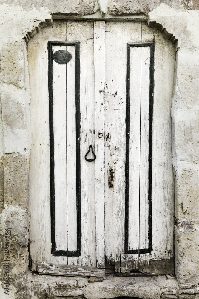 Old and worn white wooden door in Bozcaada, Canakkale, Turkey