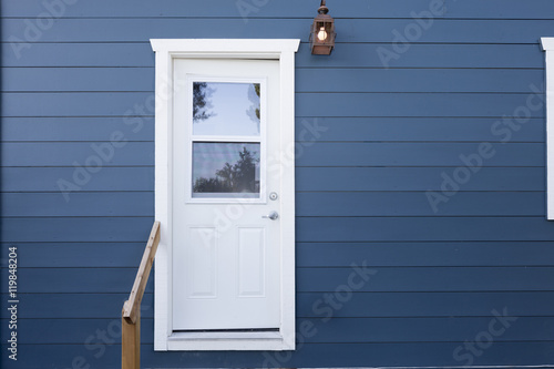 Closed white door within blue wooden background.