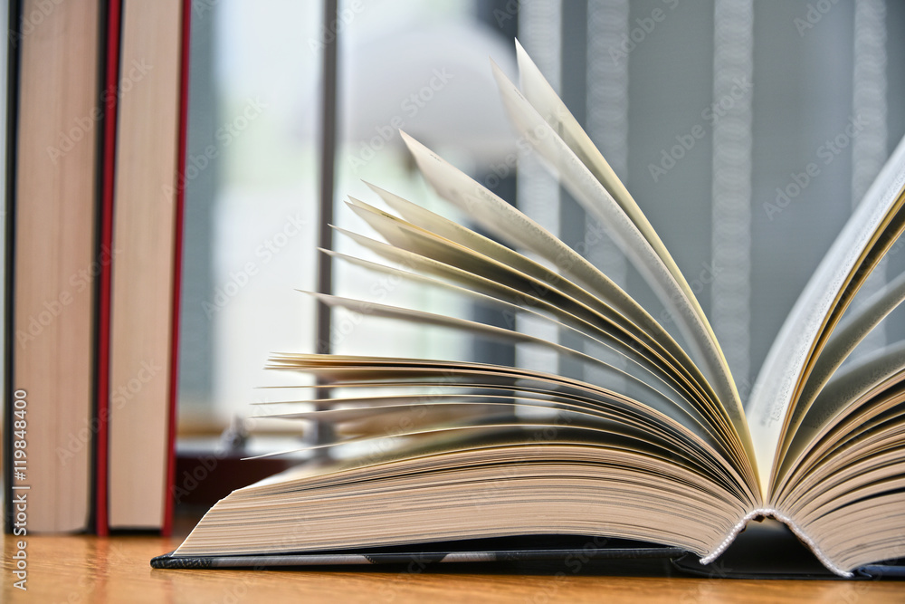 Fototapeta premium Hardcover book lying on the table in a library