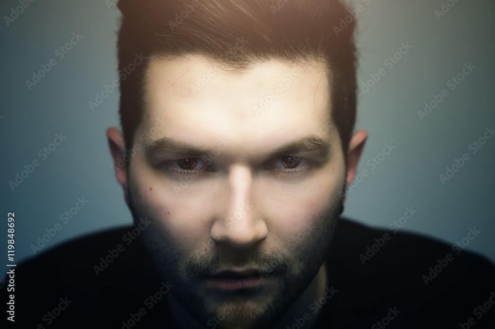 Serious hipster handsome man with evil eyes looking at you, close up studio portrait. Serious hipster handsome man with evil eyes looking at you, close up studio portrait.