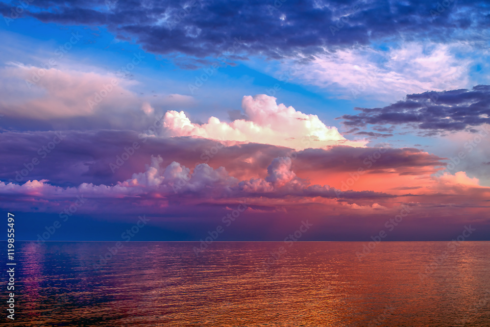 Colorful clouds over the lake in the light of sunset 