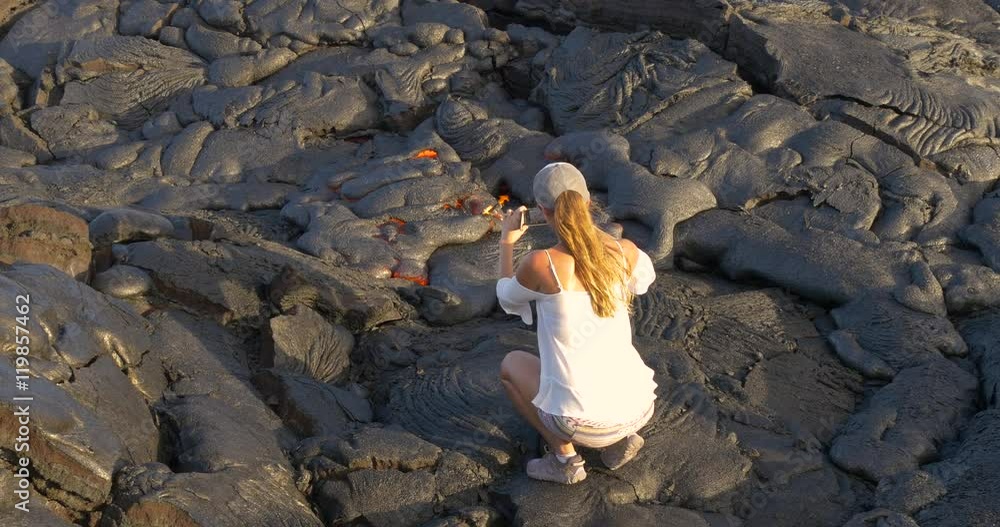 Girl taking picture flowing lava in Kilauea volcano Hawaii.Tourist taking photo of flowing lava from Kilauea volcano around Hawaii volcanoes national park, USA. Girl taking picture flowing lava in Kilauea volcano Hawaii.Tourist taking photo of flowing lava from Kilauea volcano around Hawaii volcanoes national park, USA.