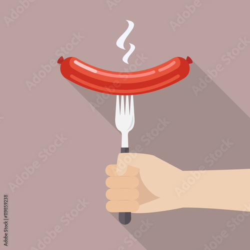Hand holding grilled sausage on the fork