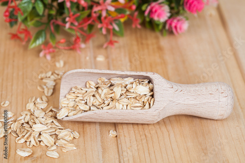  wood spoon with oats flakes pile on wood