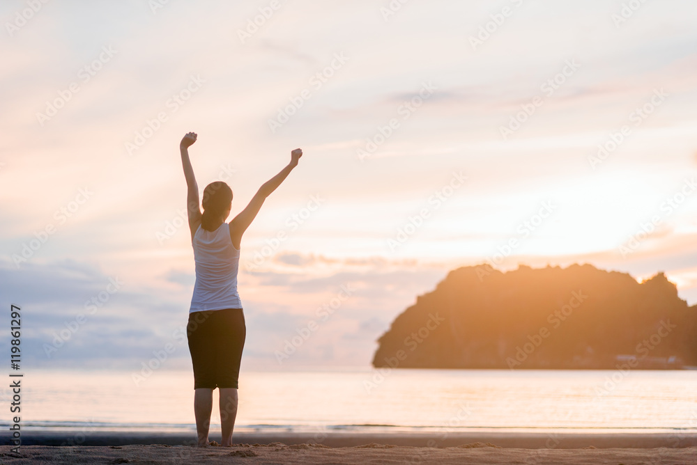 Relaxed woman breathing fresh air at on the beach sunrise.