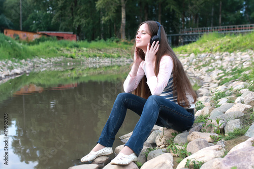 girl listen music in headphone outdoor © alexkich