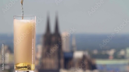 famous german beer called Kölsch pouring in a beer glas in front of the cologne cathedral