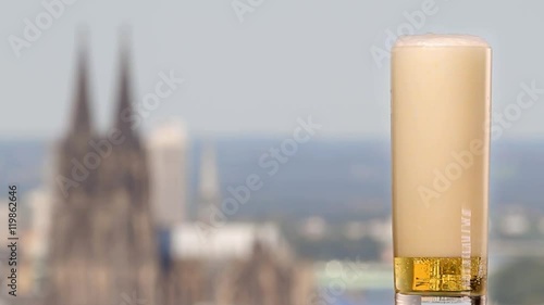 famous german beer called Kölsch pouring in a beer glas in front of the cologne cathedral