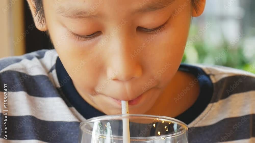 Asian boy drinking water from straw Asian boy drinking water from straw
