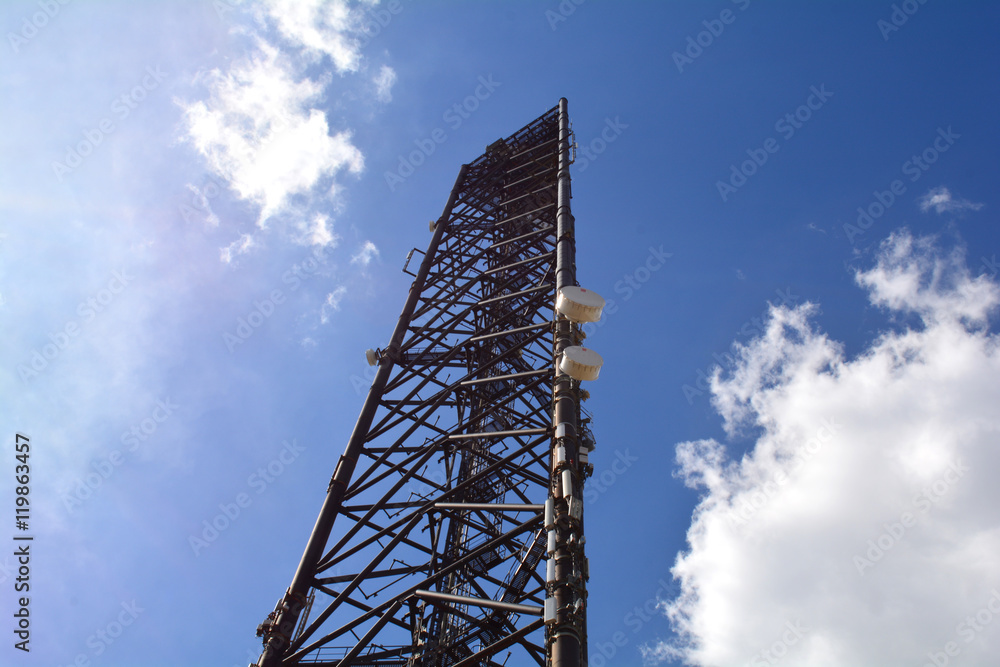 Telecommunication mast television antennas on blue sky. Site, mobile operator antenna or aerial. Cell phone base station, mobile phone network. Cell site, cell tower or cellular telephone site. Telecommunication mast television antennas on blue sky. Site, mobile operator antenna or aerial. Cell phone base station, mobile phone network. Cell site, cell tower or cellular telephone site.