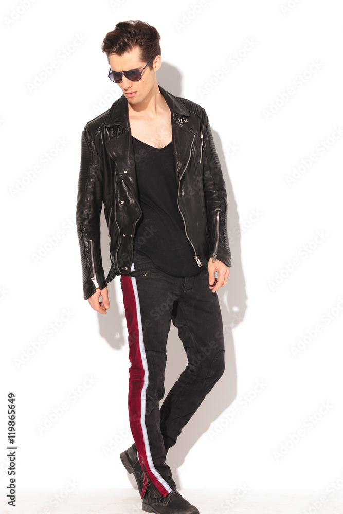 Fototapeta premium rocker man in leather jacket and sunglasses walking