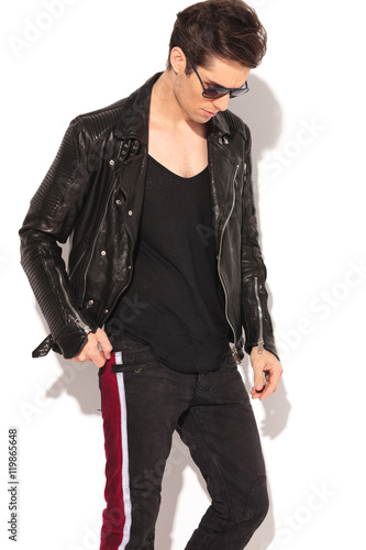 fashion man in leather jacket and sunglasses looking down photo