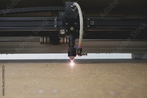 Fotografie Laser cutting machine carving patterns on the plastic plate.