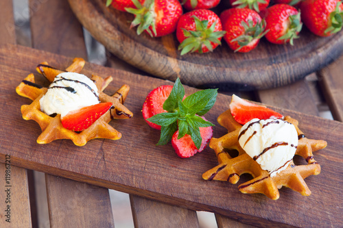 Viennese waffles with stawberry, ice-cream and chocolate, decorated with mint. Belgian waffle.