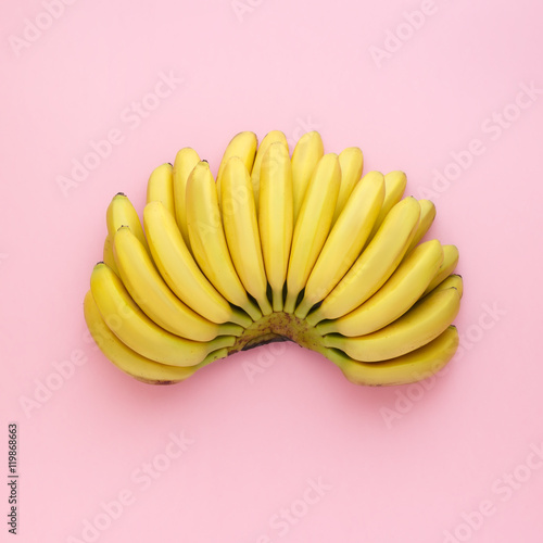 Top view of ripe bananas on a bright pink background. Minimal style.