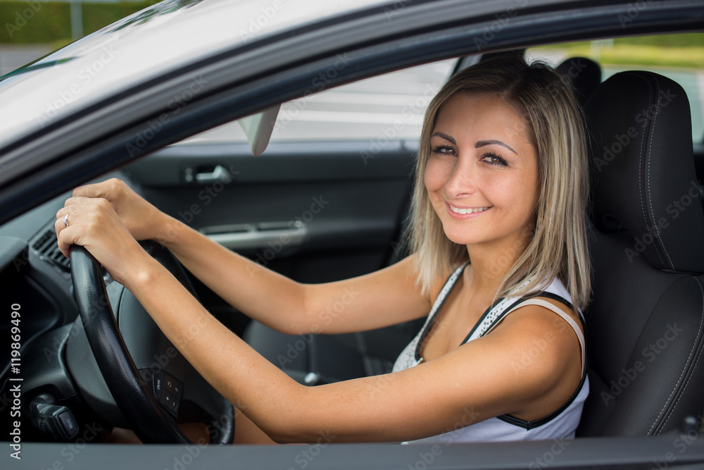 Woman driving a car - female driver at a wheel of a modern car,