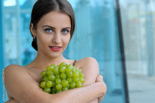 Girl put a bunch of grapes on her chest