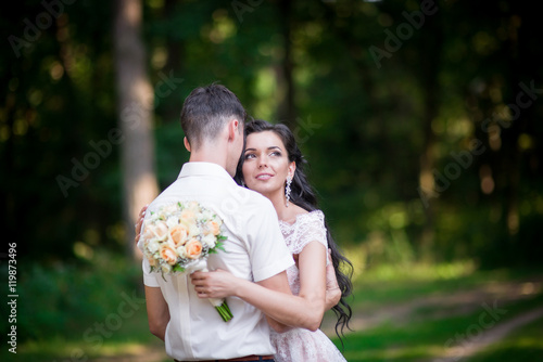 Beautiful luxury newlyweds posing outside