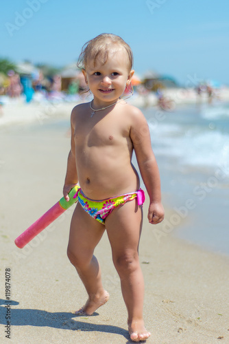 The child, a little girl playing on the beach.