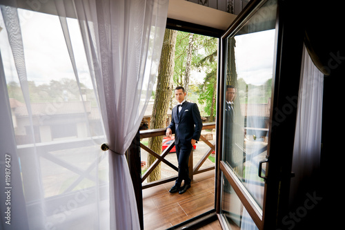 Handsome groom is waiting his bride on balcony © IVASHstudio
