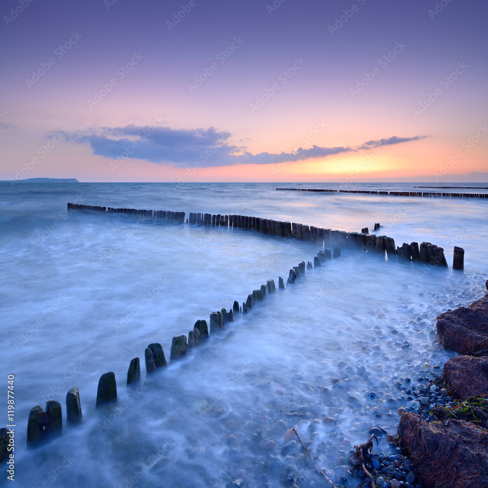 Obraz premium Coastal Sunset on the Baltic Sea, Wooden Groynes, Rügen Island, Germany