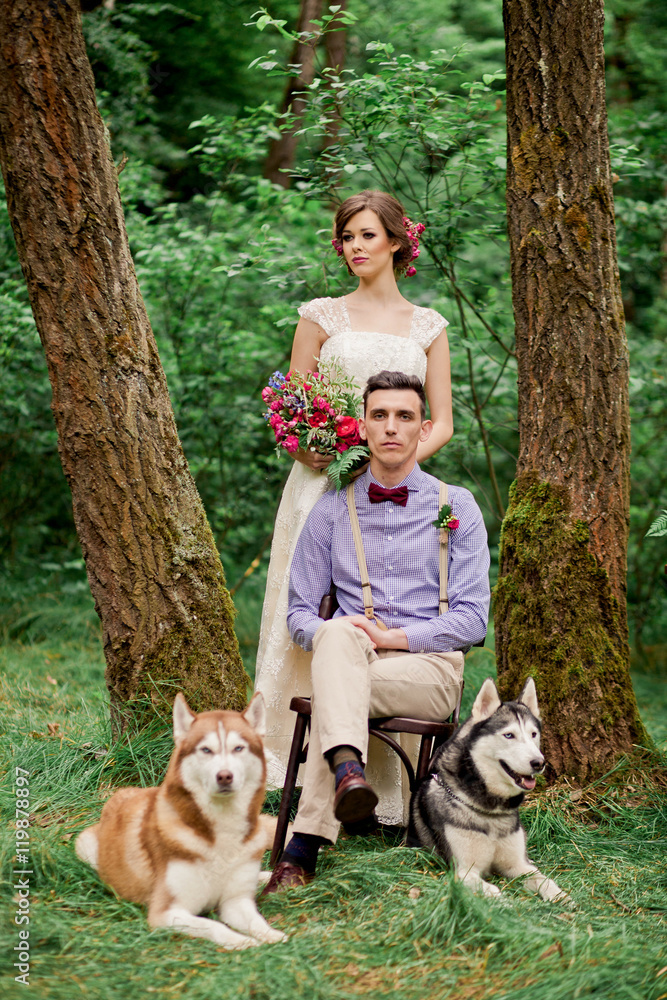 Amazing wedding couple with huskies in forest Amazing wedding couple with huskies in forest