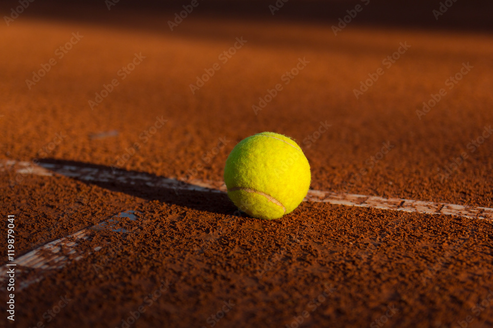Piłka tenisowa z rakietą na korcie ceglanym