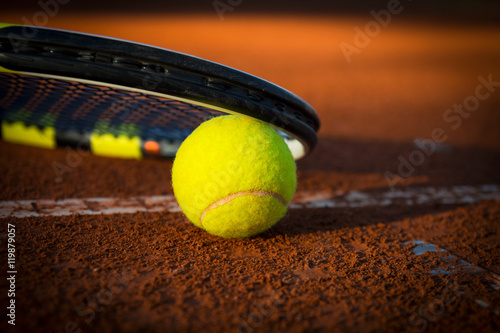 Piłka tenisowa z rakietą na korcie ceglanym © duncaen