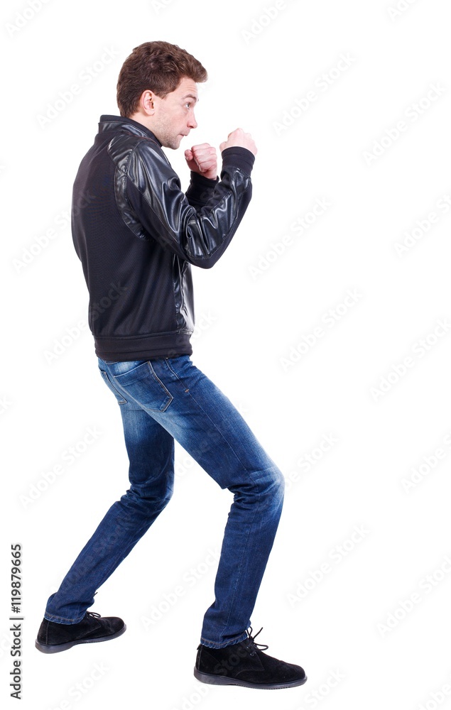 back view of guy funny fights waving his arms and legs. Curly guy in a black leather jacket in a fight. back view of guy funny fights waving his arms and legs. Curly guy in a black leather jacket in a fight.