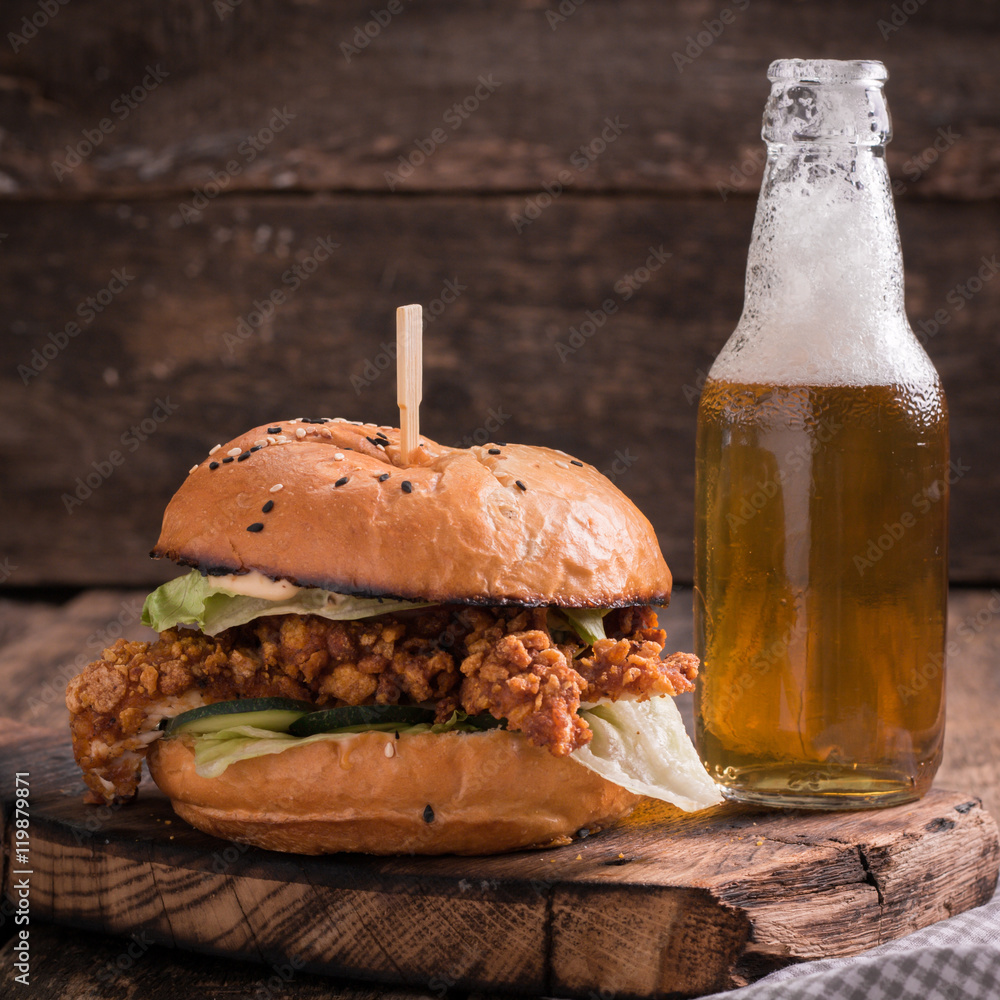 Fresh and tasty hamburger with a beer on a wooden table. Fresh and tasty hamburger with a beer on a wooden table.
