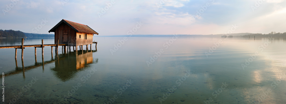 Naklejka premium Fishing Hut by Calm Lake at Sunset, Clouds Reflecting in the Water, Ammersee, Bavaria