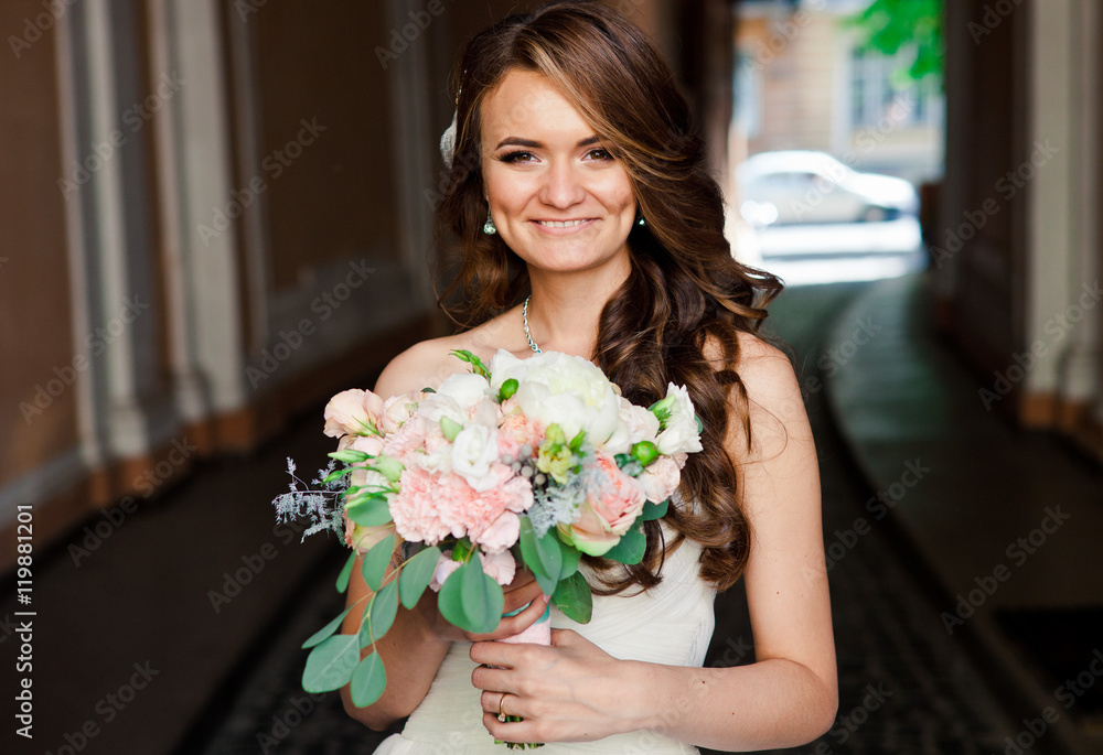 Pretty happy bride is standing with her tender bouquet Pretty happy bride is standing with her tender bouquet