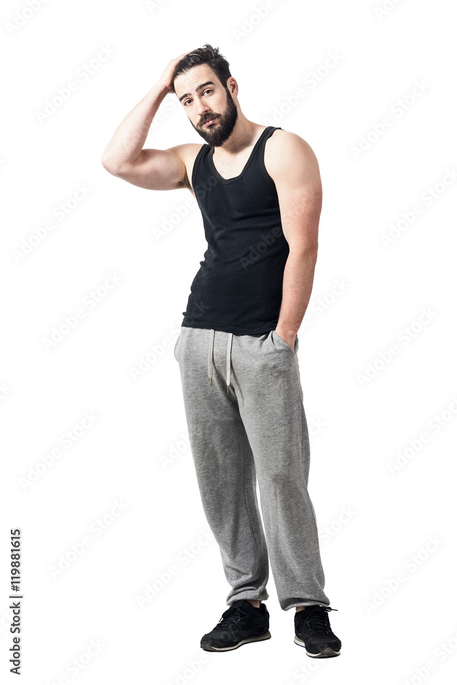Cool relaxed athlete in black tank top with hands running through hair. Toned desaturated full body length portrait isolated on white studio background. Cool relaxed athlete in black tank top with hands running through hair. Toned desaturated full body length portrait isolated on white studio background.