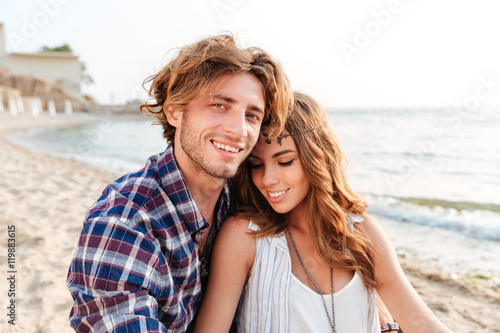 Couple sitting and smiling on the beach