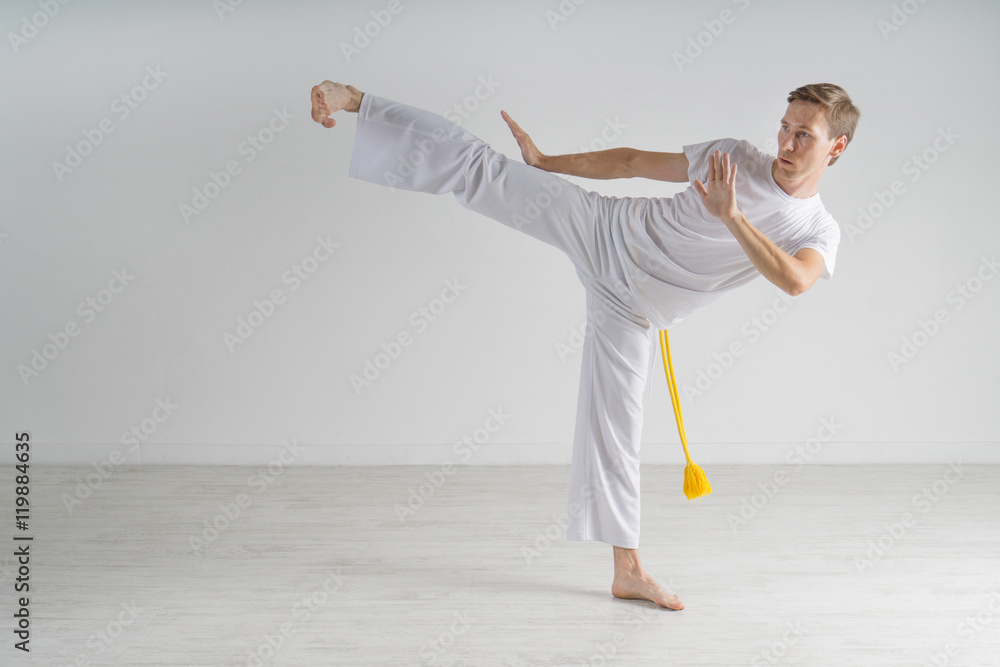 Man in sportswear performing a kick. Man in sportswear performing a kick.