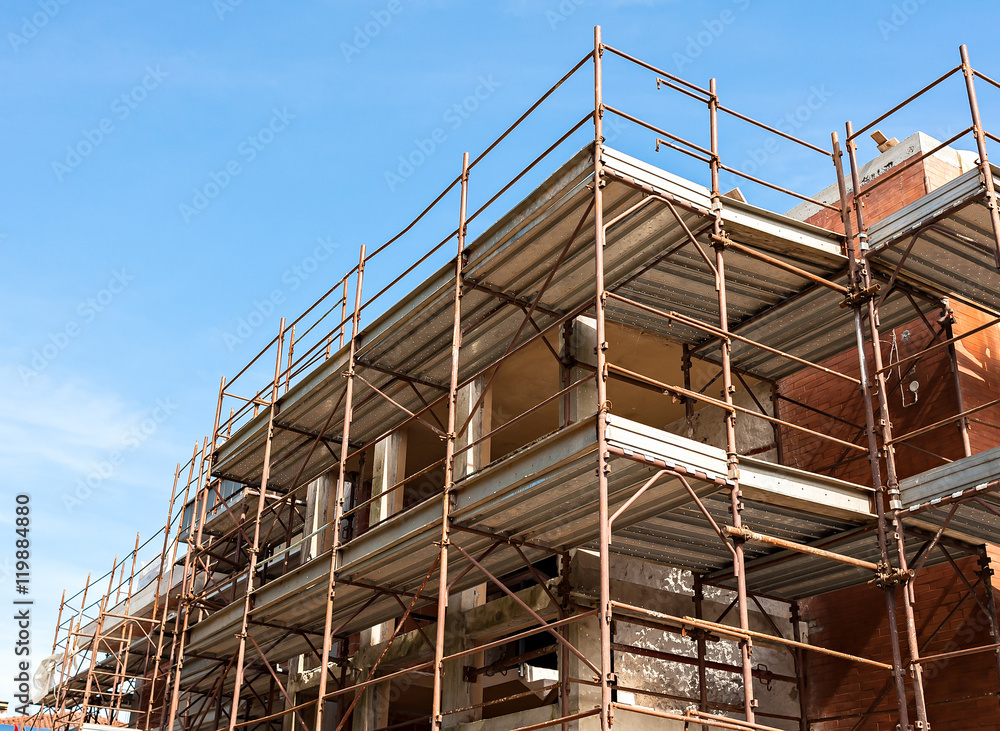 House for renovation with the scaffolding for bricklayers House for renovation with the scaffolding for bricklayers