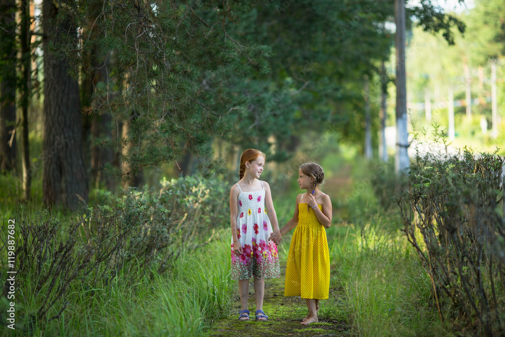 Two little cute girls go and talk in the Park. Two little cute girls go and talk in the Park.