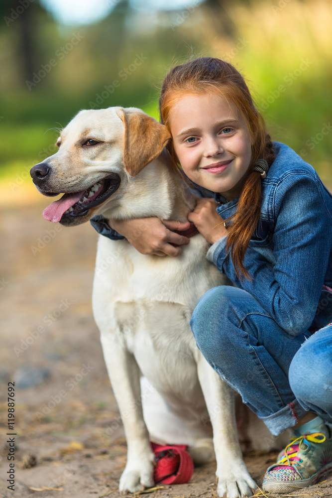 Little girl hugging a dog during a walk.