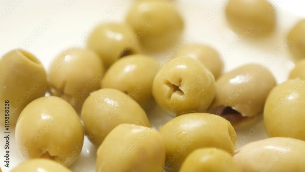 Marinated green european table olives fermented and served on the plate slow tilt 4K 2160p 30fps UltraHD video - Oleae europaea tasty ripe fruit tilting 4K 3840X2160 UHD footage 