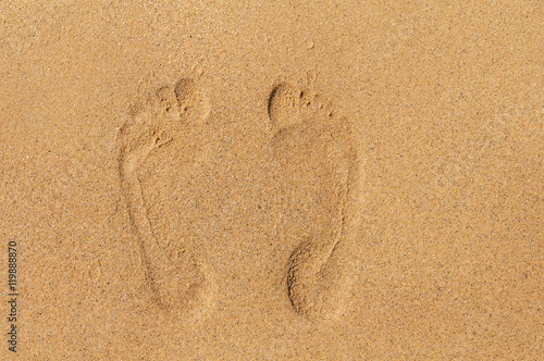 Two footprints in sand on beach