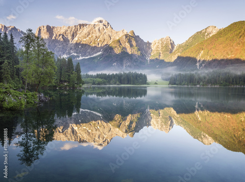Jezioro alpejskie o świcie,pięknie oświetlone szczyty gór