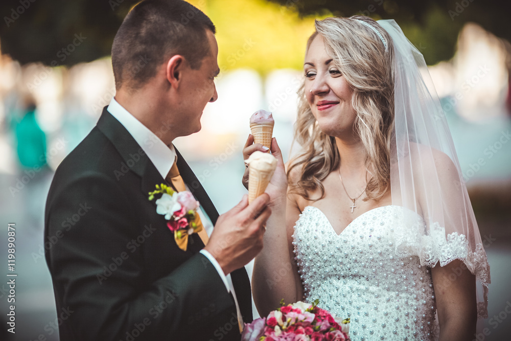 Beautiful young wedding couple enjoying ice cream