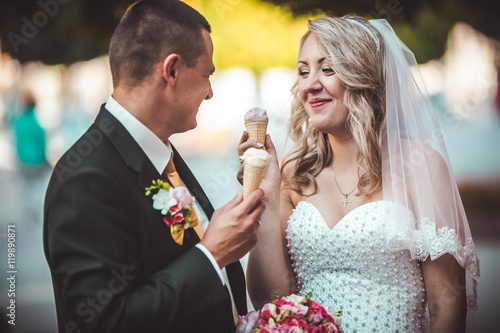 Beautiful young wedding couple enjoying ice cream