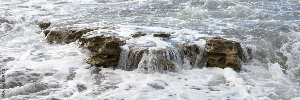 Breaking waves with foam on the rocky coast Breaking waves with foam on the rocky coast
